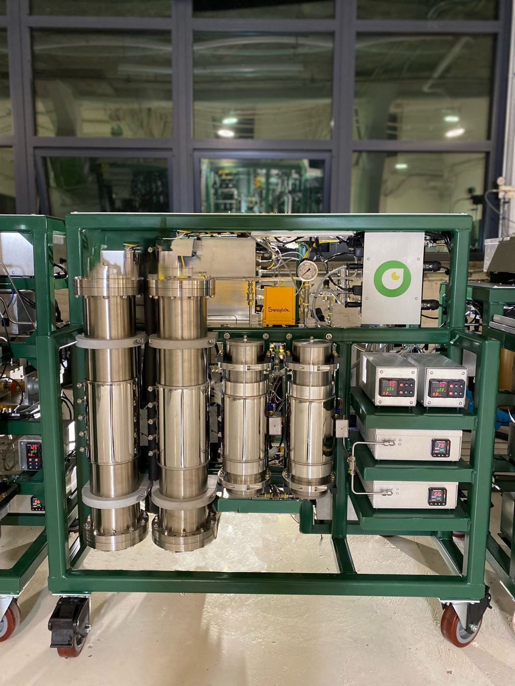 Green-framed pilot-scale CO₂ extraction skid with stainless vessels and controllers